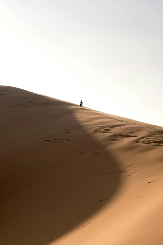 lone person in the distance standing alone on the side of a desert