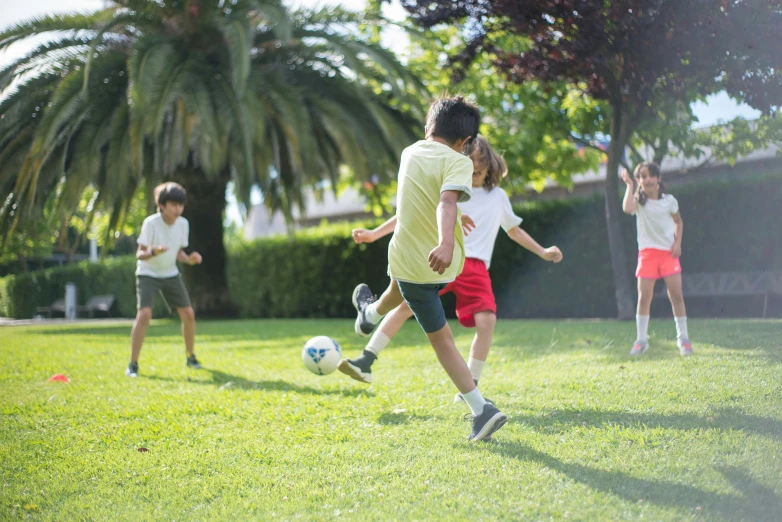 several children playing soccer in the grass together