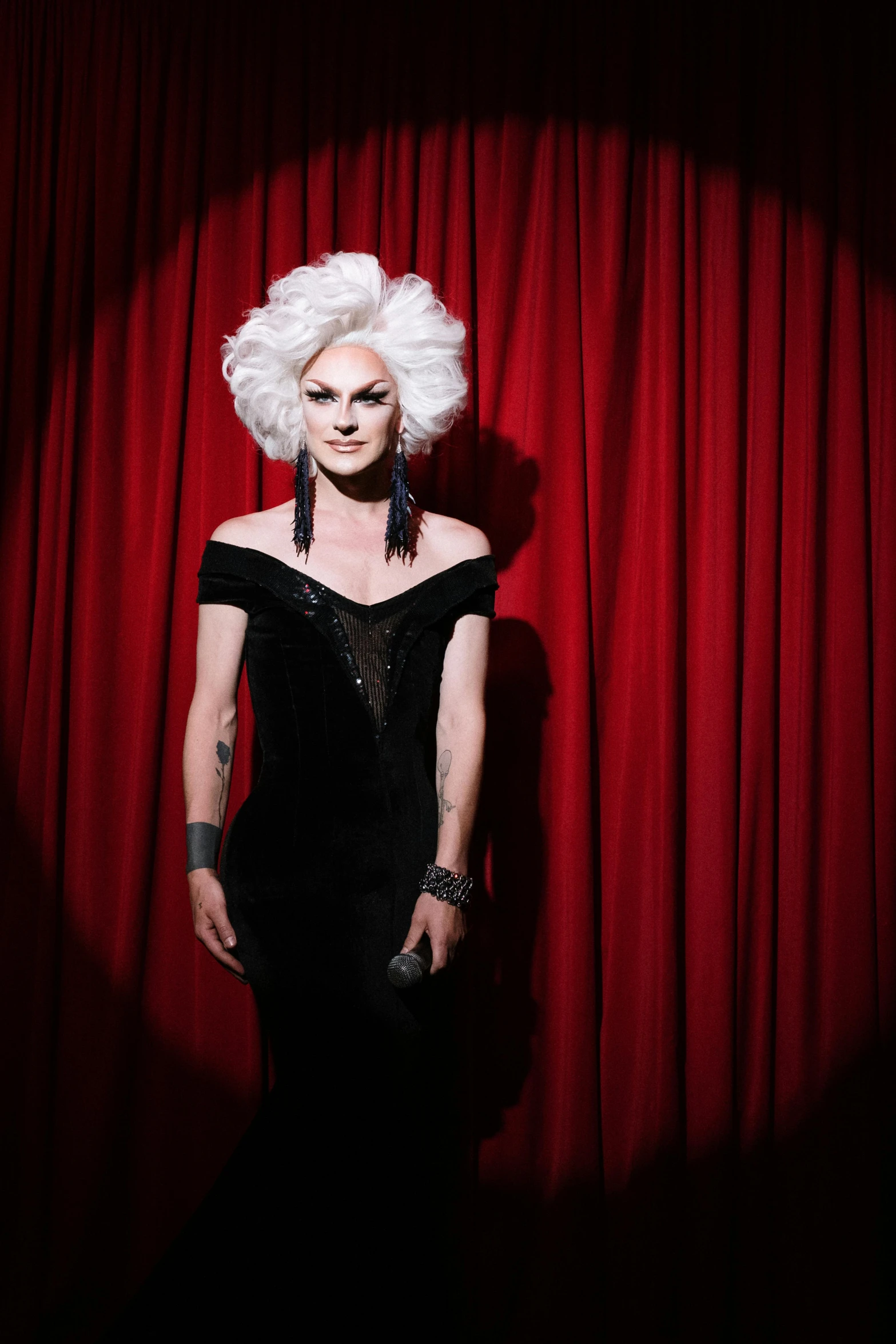 a woman with white hair in front of a curtain