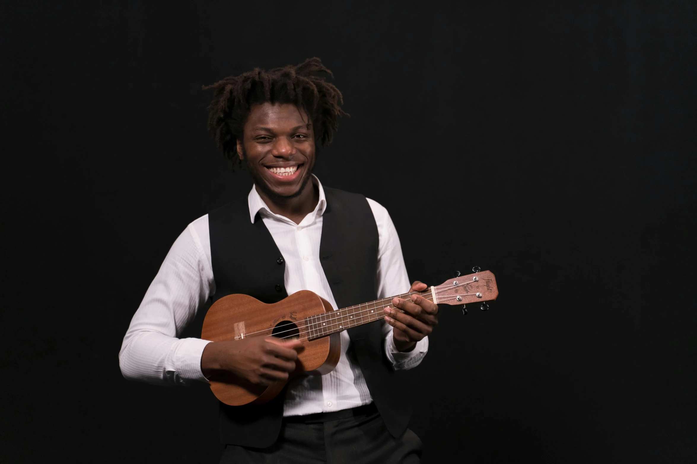 a black man wearing a suit and tie plays an ukulele