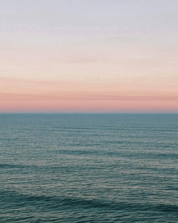 the sky is pink and blue over the water