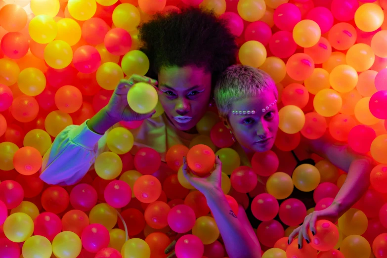 two children in a ball pit with many balls