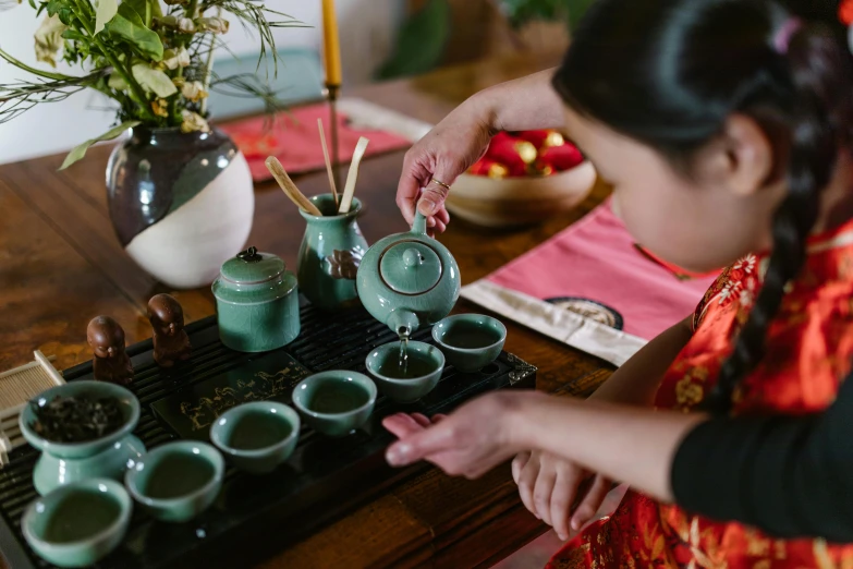 a woman standing at a table with cups on it