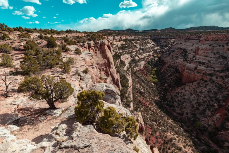 a cliff on the edge of a rocky area under cloudy skies