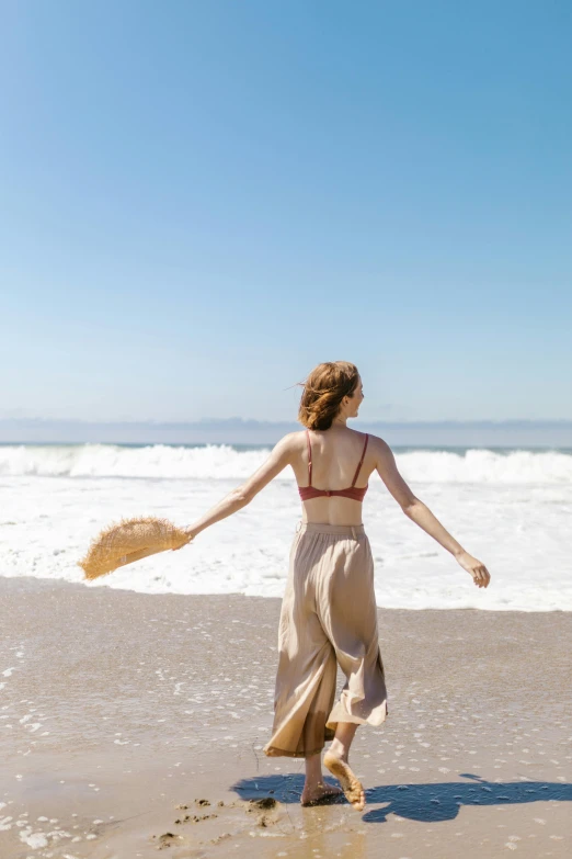 the woman is on the beach throwing a frisbee