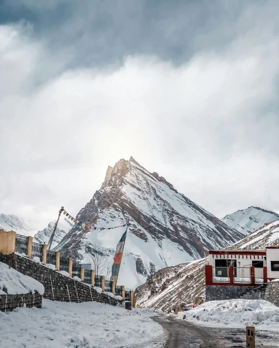 a snowy mountain covered in white snow sitting next to a road