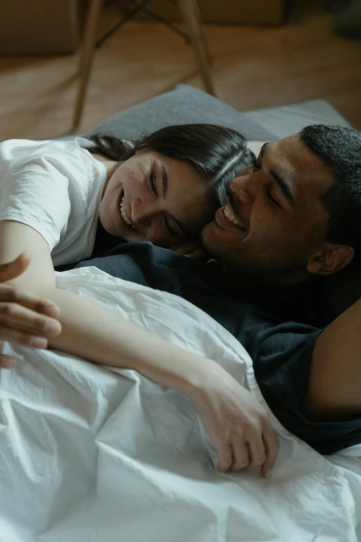 a man and a woman laying on a bed