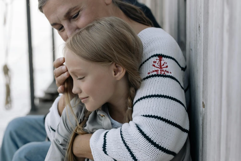 a man standing behind a girl who is leaning against a wall