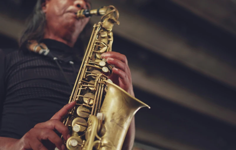 a man that is playing a saxophone in his hand