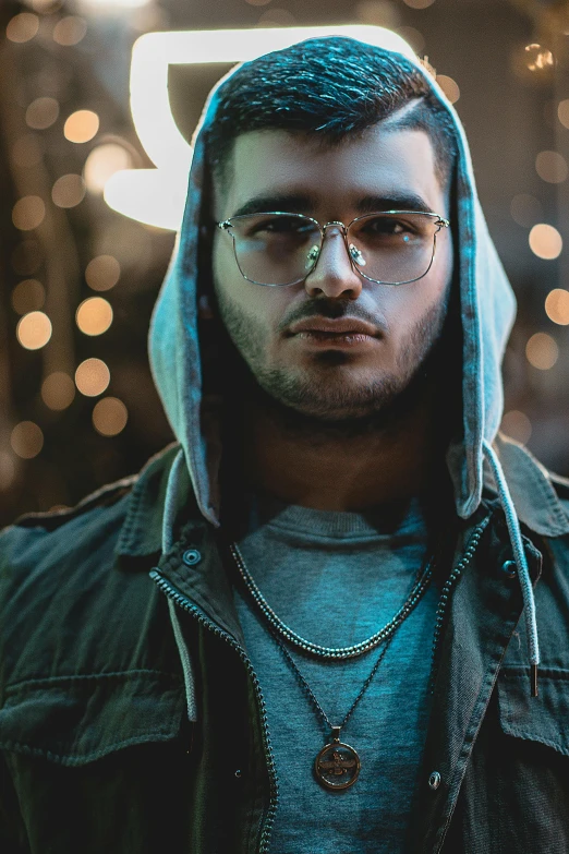 a man in a hoodie with glasses on staring at the camera