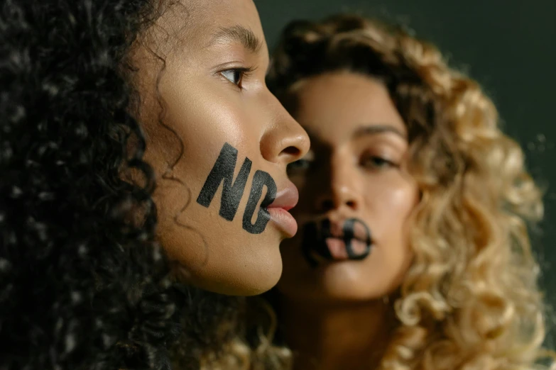 two women with painted faces pose for a pograph