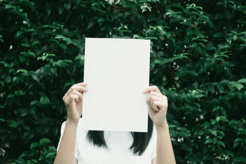 woman holding a white sheet in front of her face