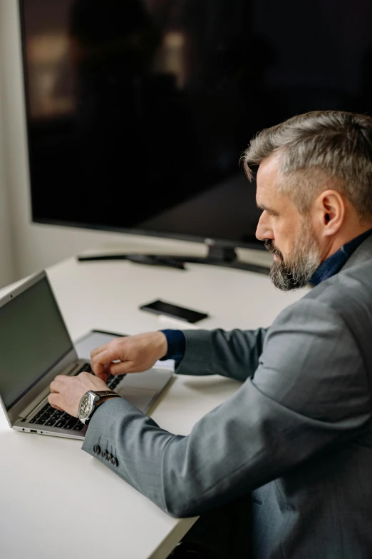 a man with his laptop computer sitting at a desk