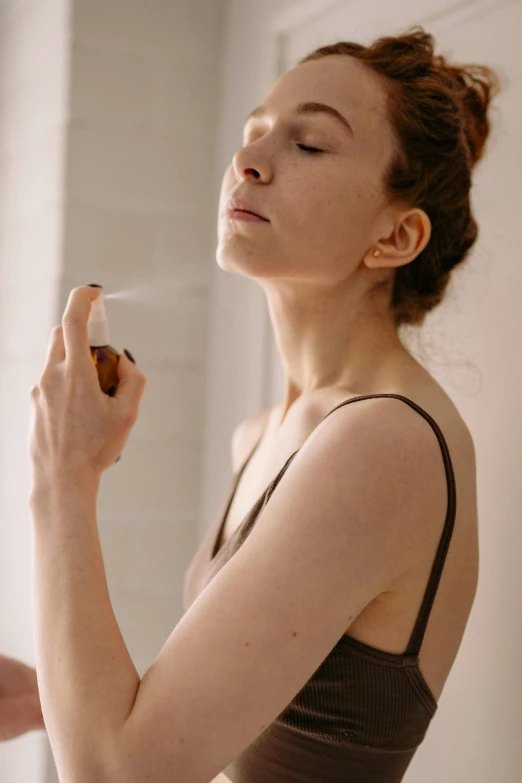 a woman using a white brush to apply make - up