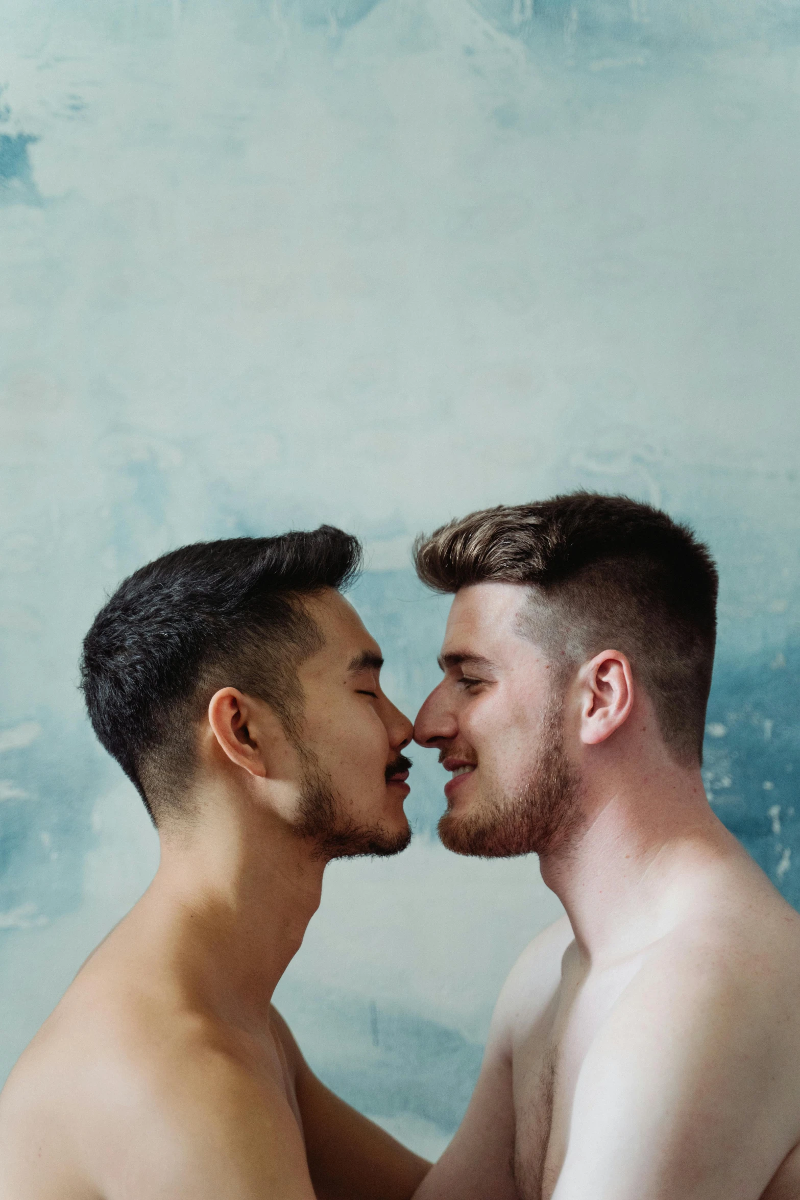 a couple of men standing next to each other near the ocean