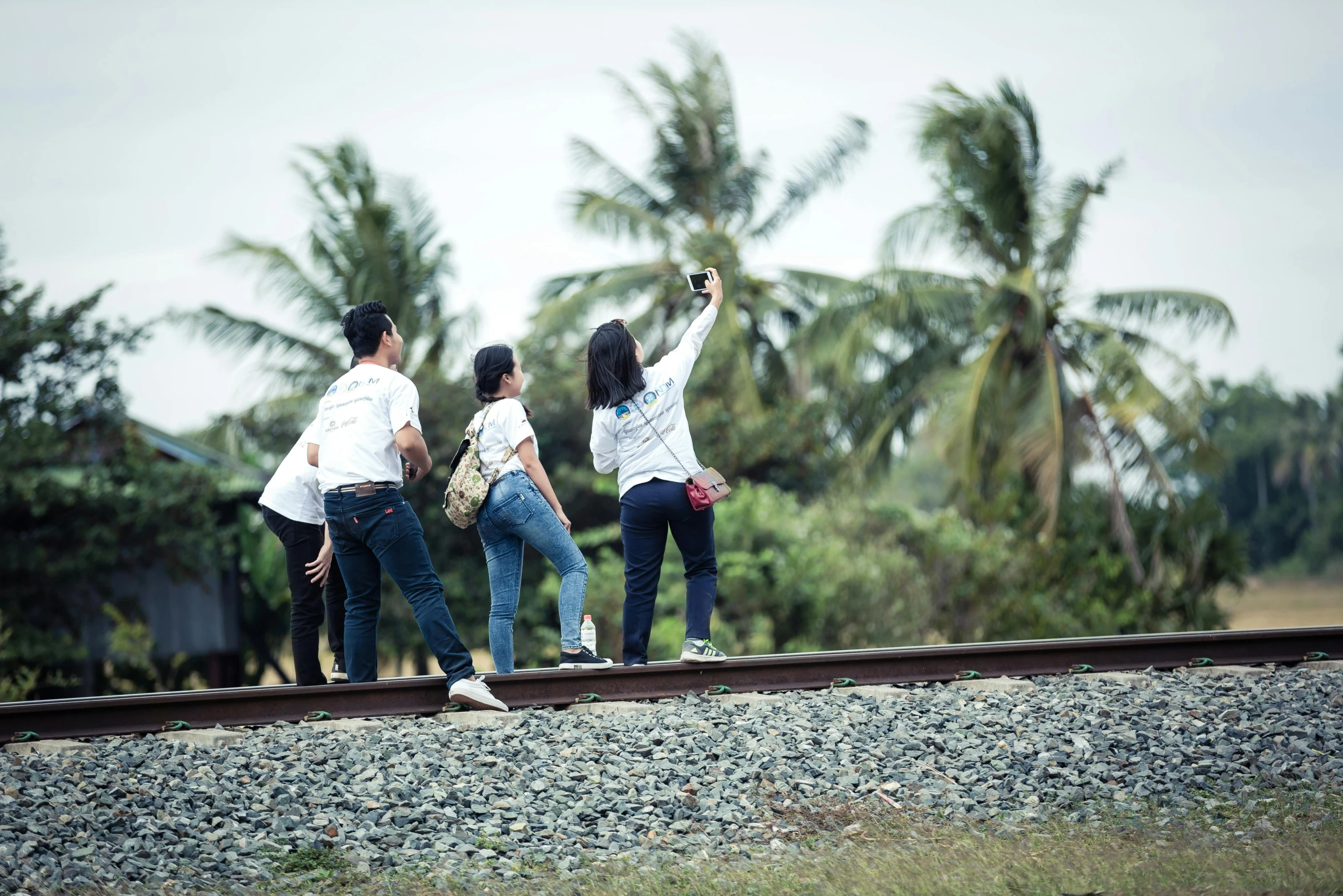 a group of people taking a picture on the train track