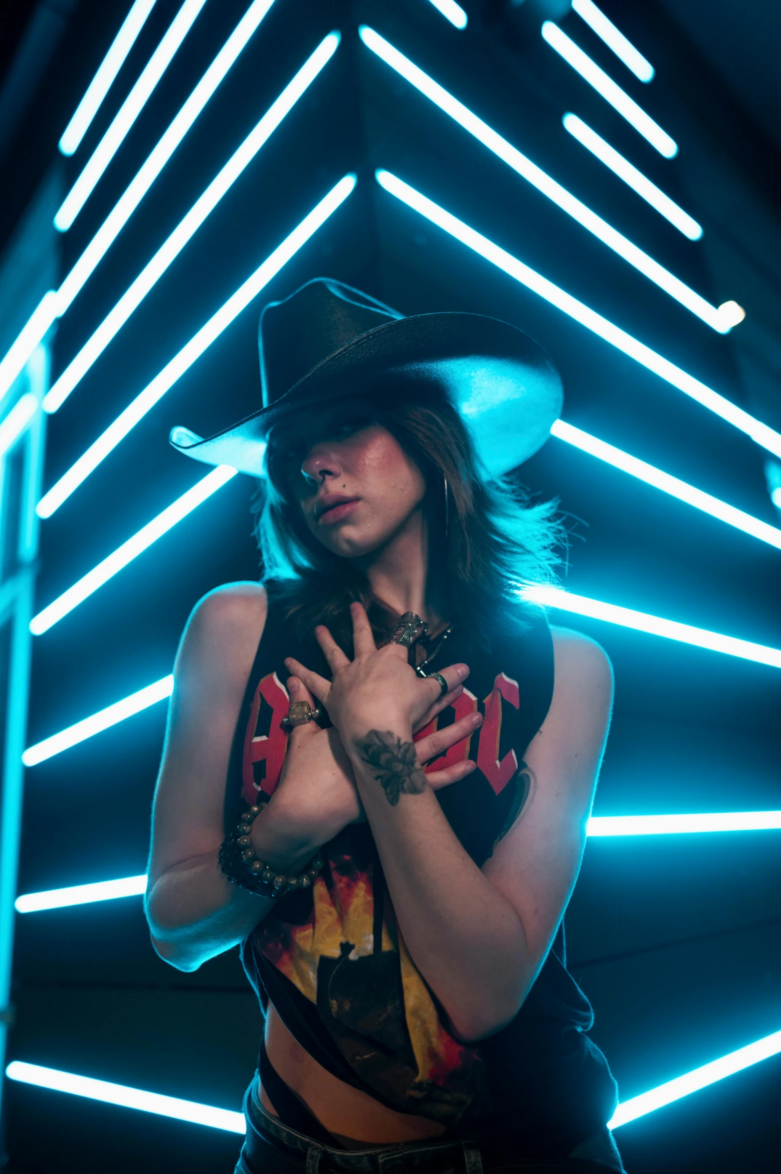 the woman is posing in front of the wall with colorful neon