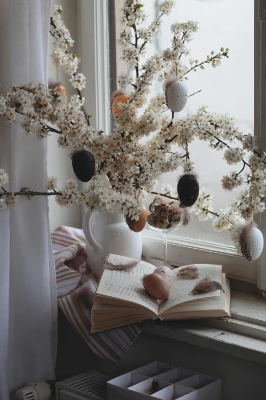 flowers in vases with books near window