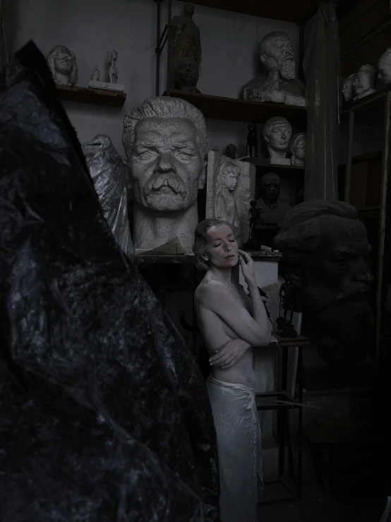 a woman poses in a room with statues