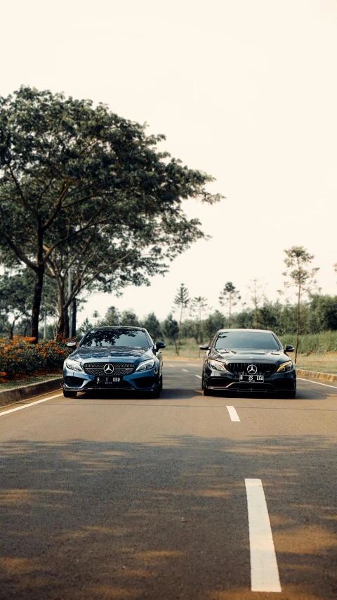 two cars driving side by side down the road