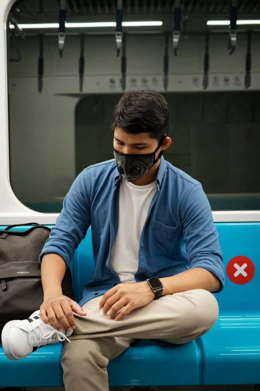 a person sits with a protective mask over their mouth