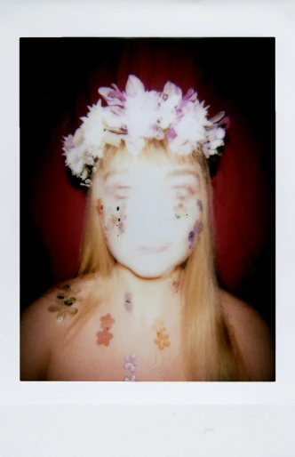 a girl wearing white flowers all over her face