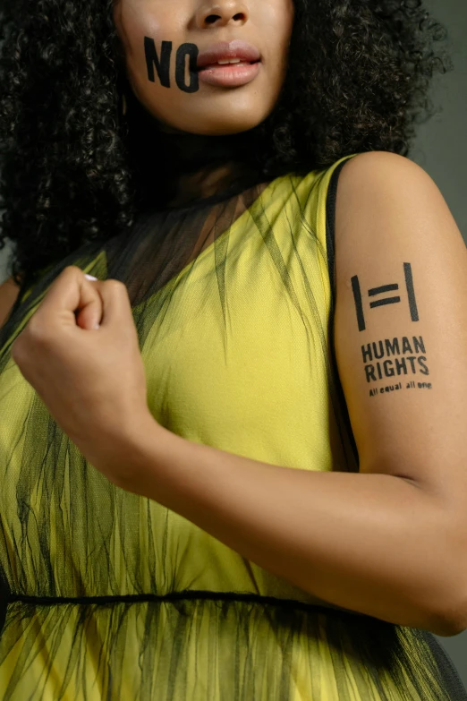 a woman wearing a green dress and writing on her arm