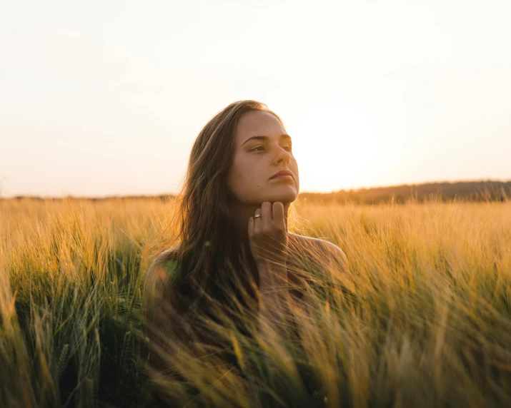 the girl is in the middle of the tall grass