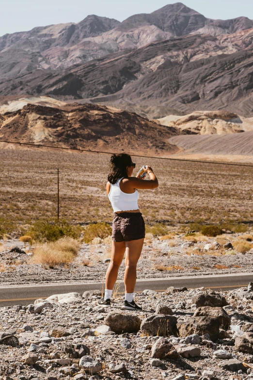 a person in a black and white outfit standing by some rocks