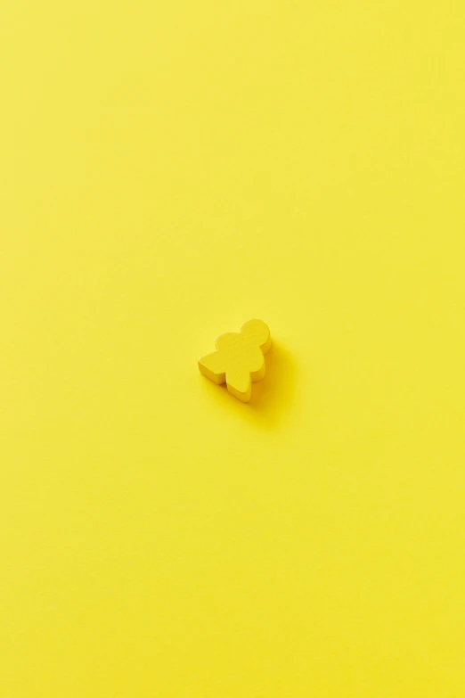 small cookie shaped like a teddy bear on a yellow surface