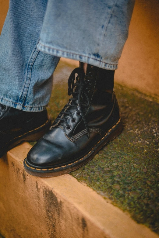 the shoe on top of a man's feet that is on cement