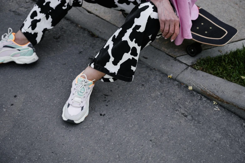 a woman is sitting on the curb with a skateboard