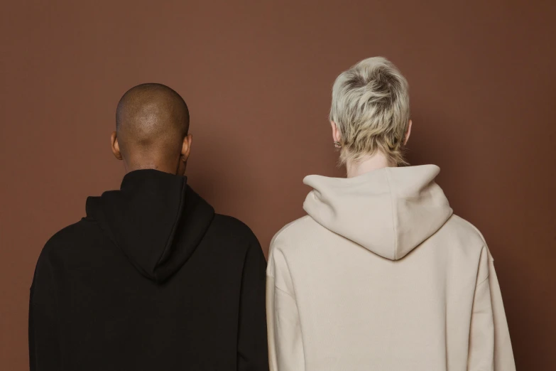 two people standing facing each other wearing hoodies