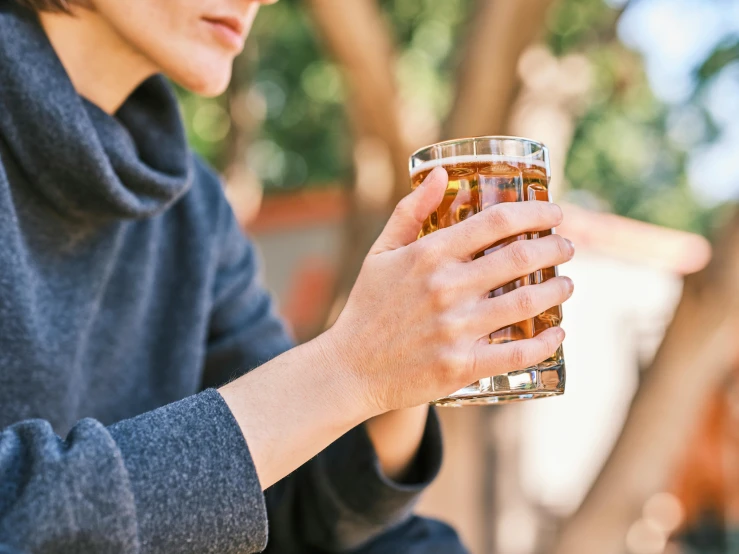 a man holding onto a glass full of soing