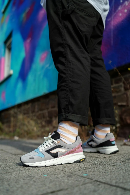 a person's feet standing on a cement slab with colorful graffiti in the background