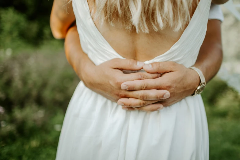 a woman in a white dress holding her hands in front of her face