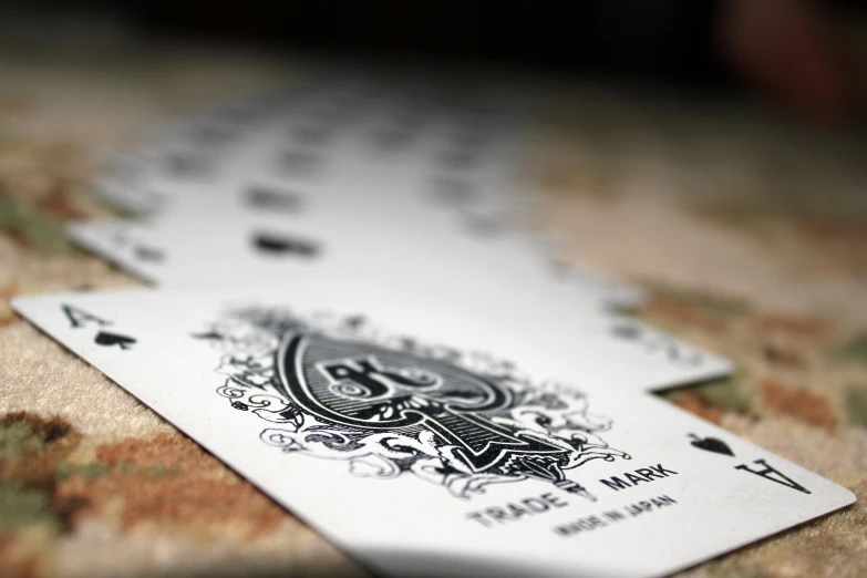 a playing card with an ornate decoration laying on top of a patterned cloth