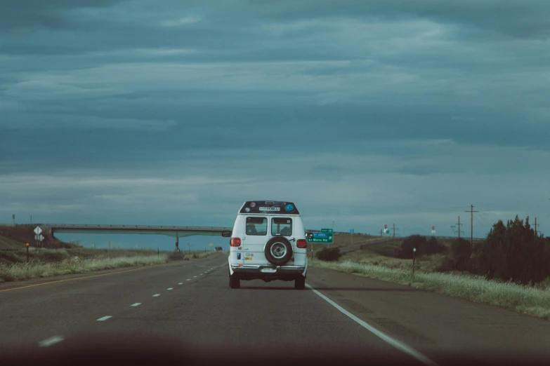 a van that is traveling down a long road