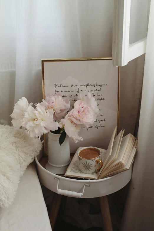 some white flowers and a book are sitting in a small corner