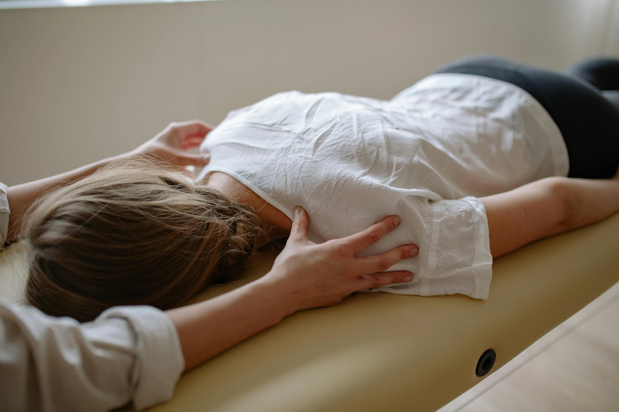 a person is laying on the table with a pillow