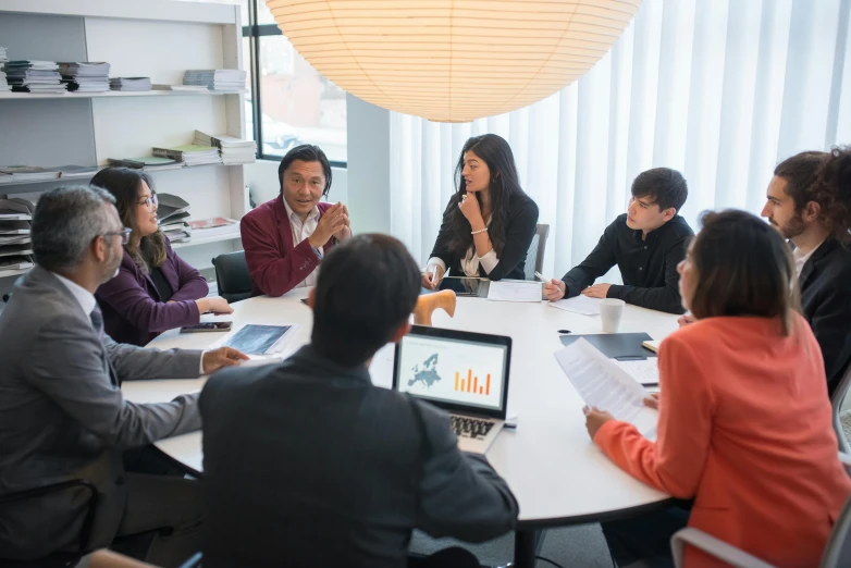 a large group of people are in a business meeting