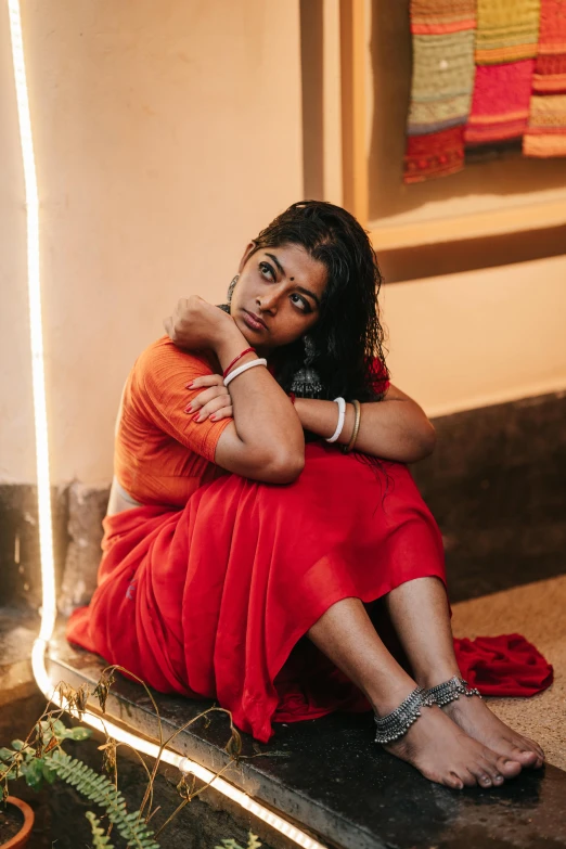 a woman sitting on the ground posing for the camera