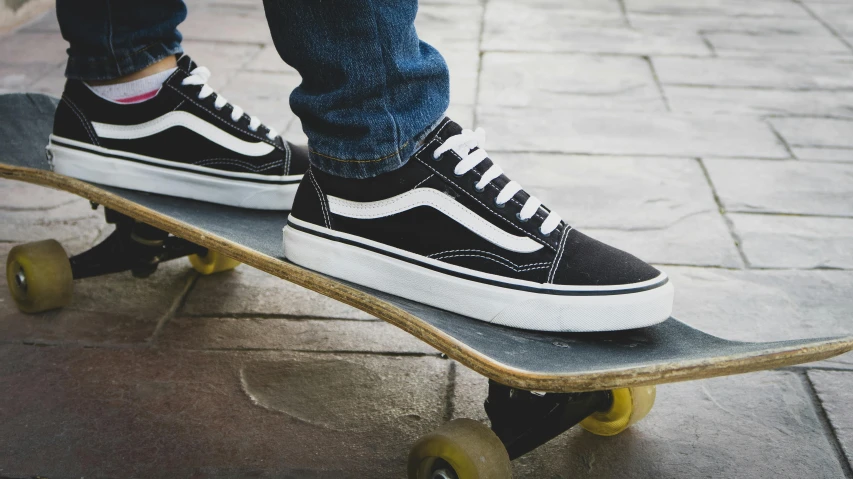 a person wearing old skools riding on a skateboard