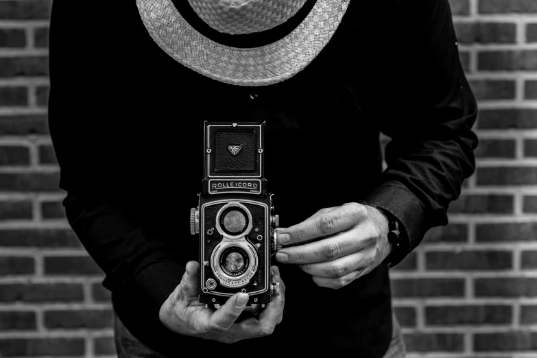 a man is holding an old fashion camera