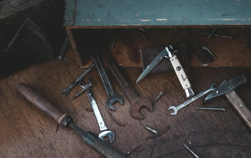 some tools are laying on the floor and one is broken