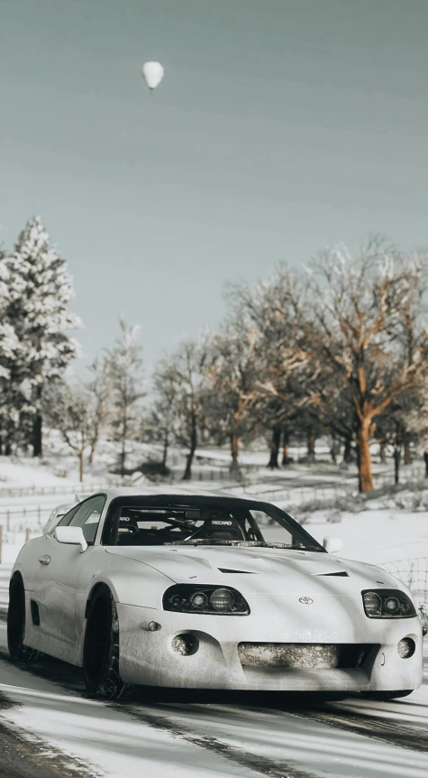 white car on snowy street in urban setting