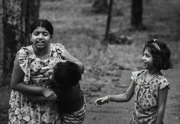 an adult woman holds a child in front of them