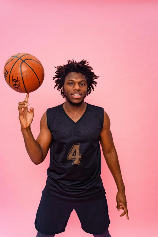 young man holding a basketball over his left hand