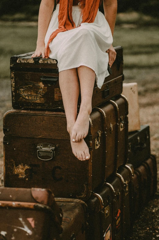 the young woman is sitting on her suit case