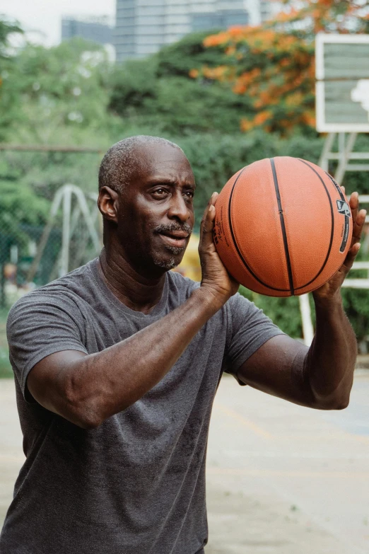 a bald man holding a basketball in his hands